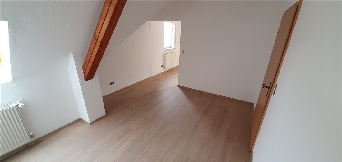 Neu verlegter Boden in einem hellen Dachgeschosszimmer